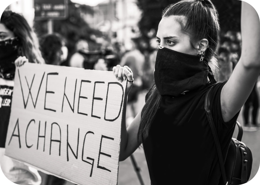 Istock image of a young protestant women holding a poster with text "We need a change"
