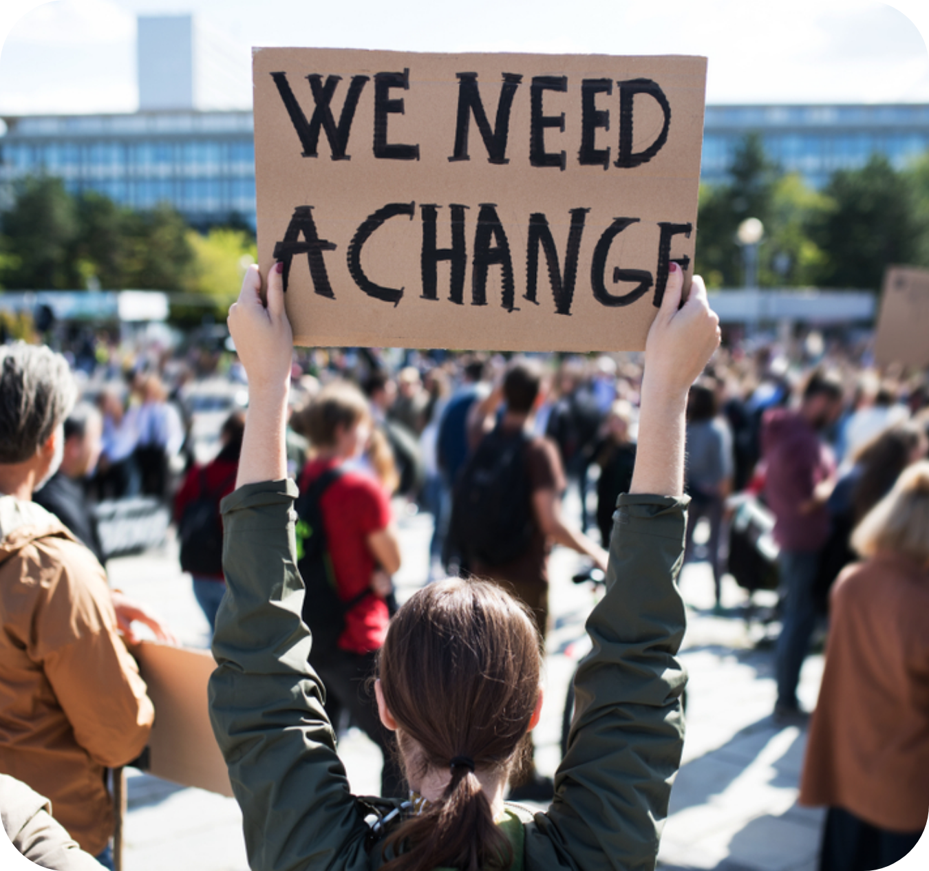 Lady holding a protest sign reading 'We need a change'