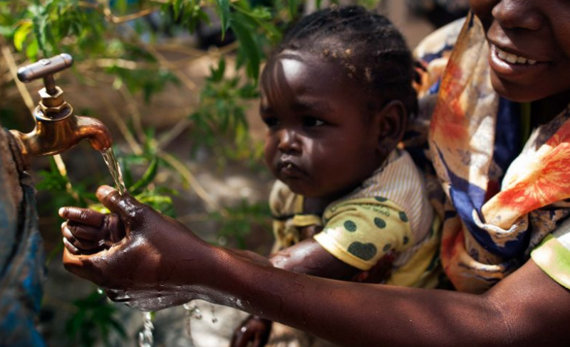 BWP project: A woman helps her child to wash hands before eating in Tawila, North Darfur. Credit: Albert Gonzalez Farran/UNAMID